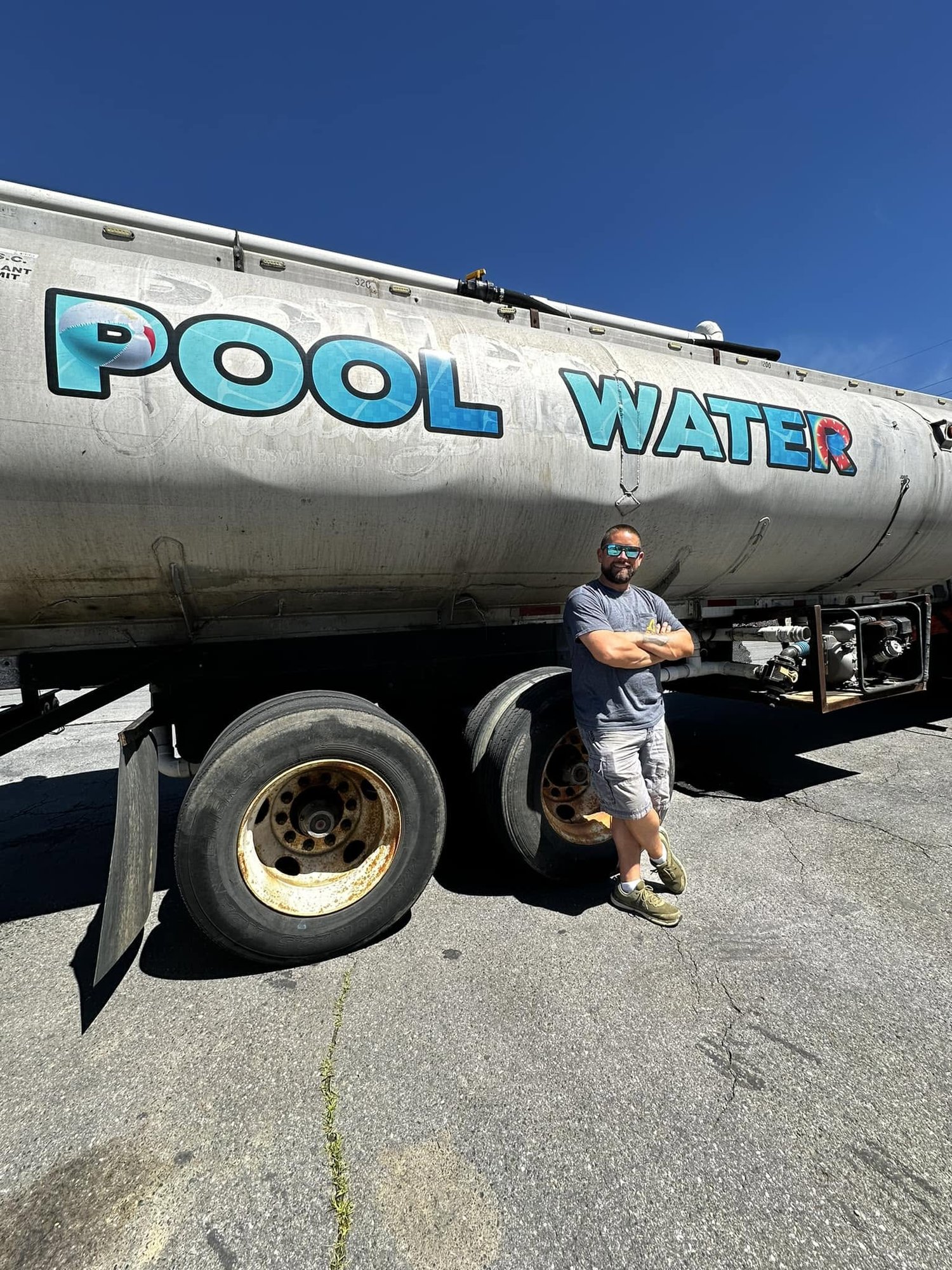 The owner of MD Pool Water beside the pool water delivery tanker in Frederick, MD